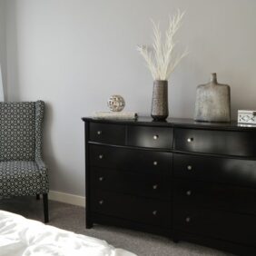 Een stijlvol dressoir in een moderne slaapkamer, perfect voor extra opbergruimte en een opgeruimde uitstraling.