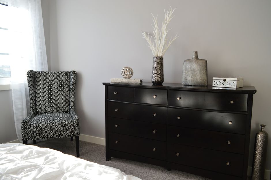 Een stijlvol dressoir in een moderne slaapkamer, perfect voor extra opbergruimte en een opgeruimde uitstraling.