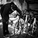Verschillende soorten fietspompen voor racefietsen met een fietser in de achtergrond.