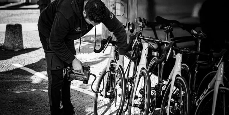 Verschillende soorten fietspompen voor racefietsen met een fietser in de achtergrond.