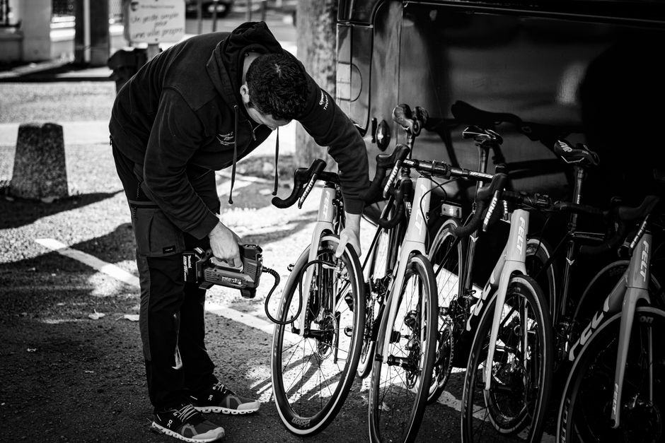 Verschillende soorten fietspompen voor racefietsen met een fietser in de achtergrond.